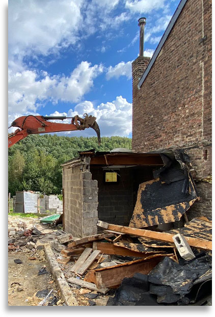 démolition d'une maison avec une pelleteuse