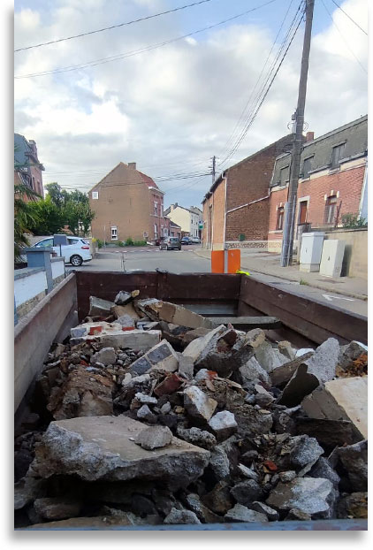container rempli de gravats et briquaillons dans une rue de la région de Liège